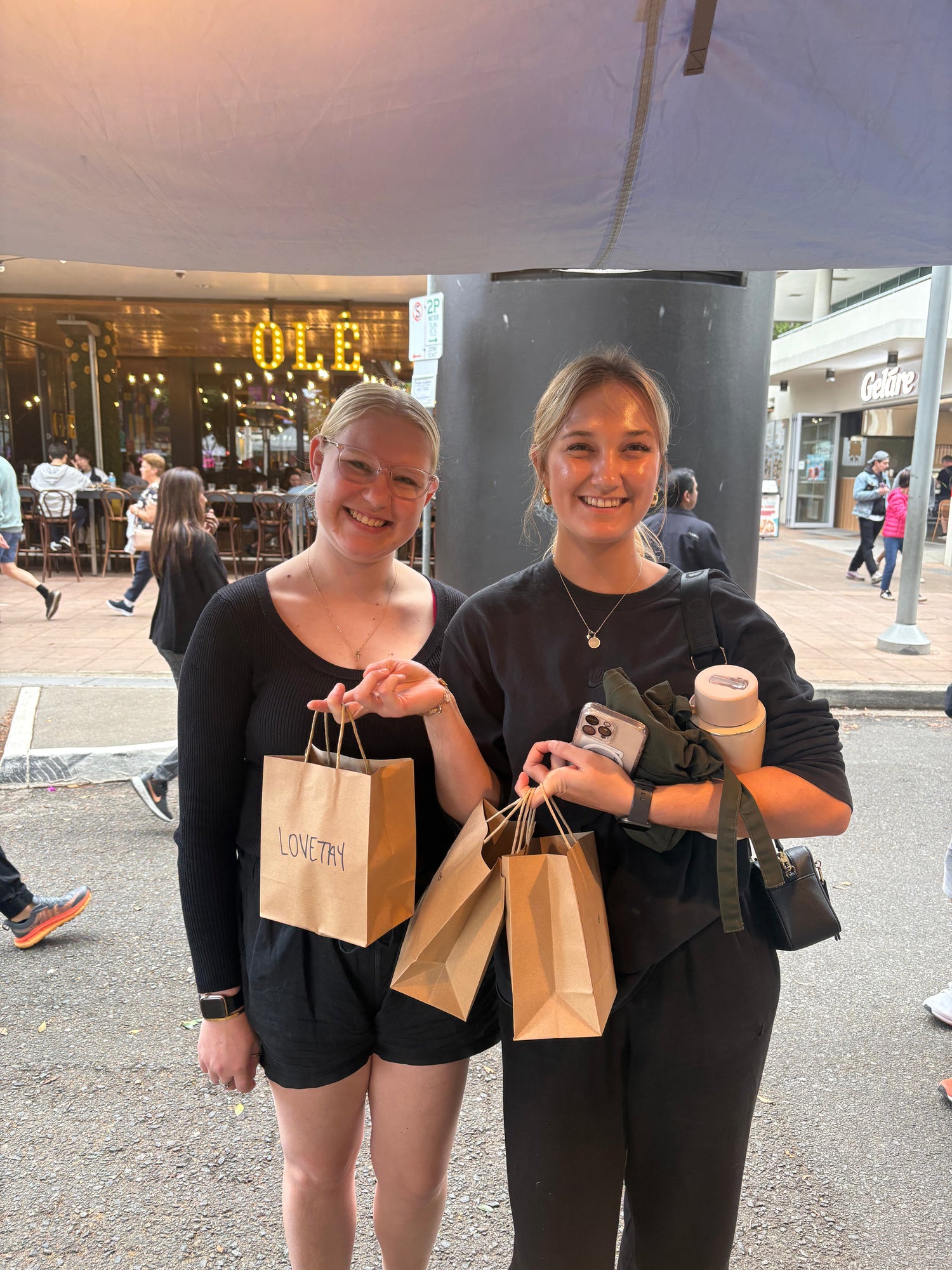 Two loyal LoveTay Candle customers holding their recent purchase