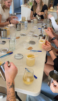 Group of girls around a table doing a LoveTay candle making class for a friends birthday