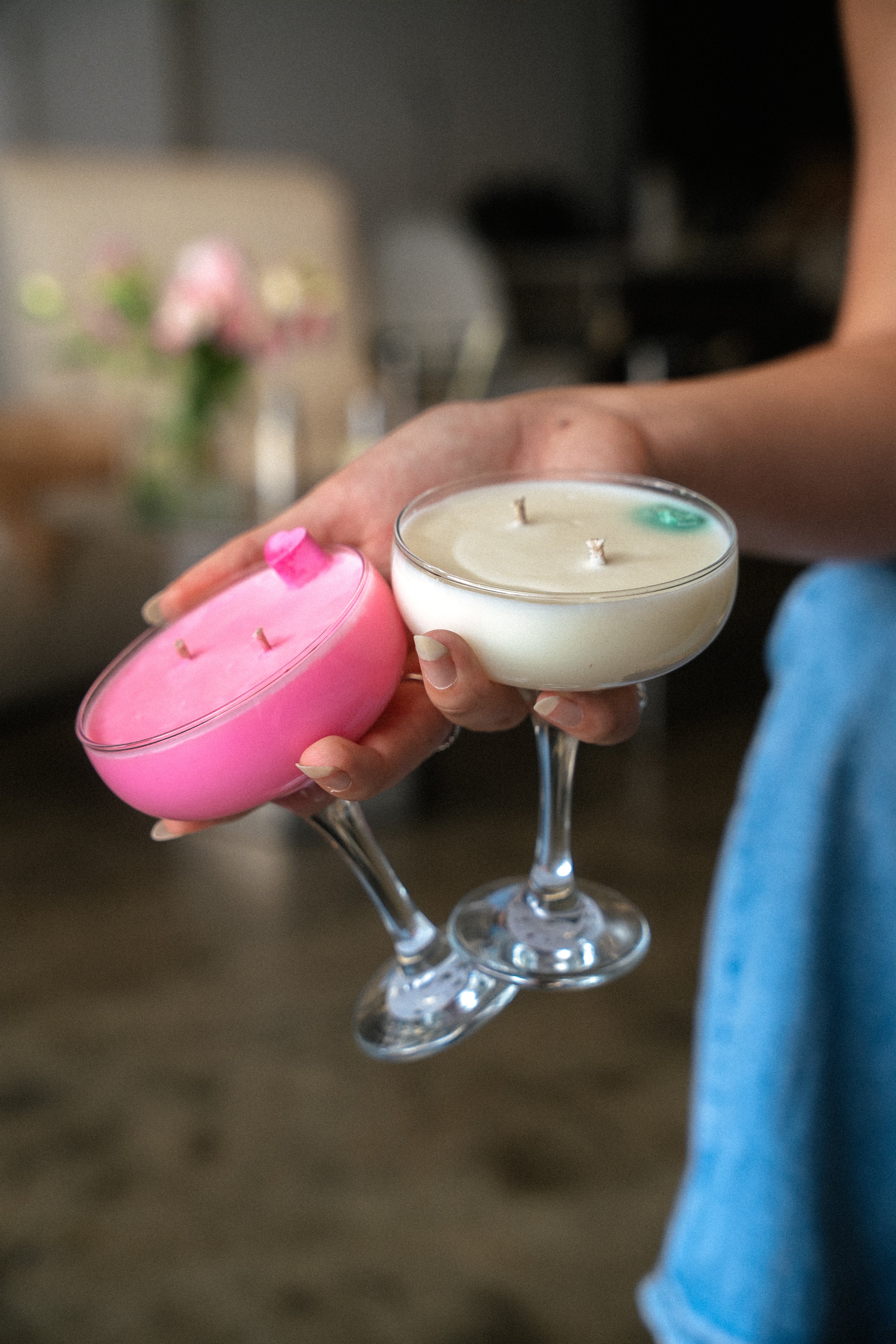 Candle shaped like a cocktail glass held by a person with a blurred background