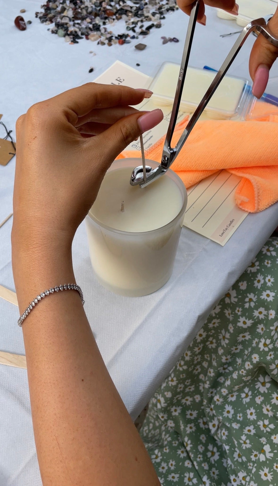 Participate of LoveTay Candle making class cutting the wick of the candle they created